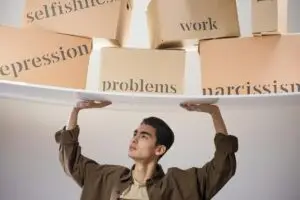 man standing with arms raised and holding boxes with problems